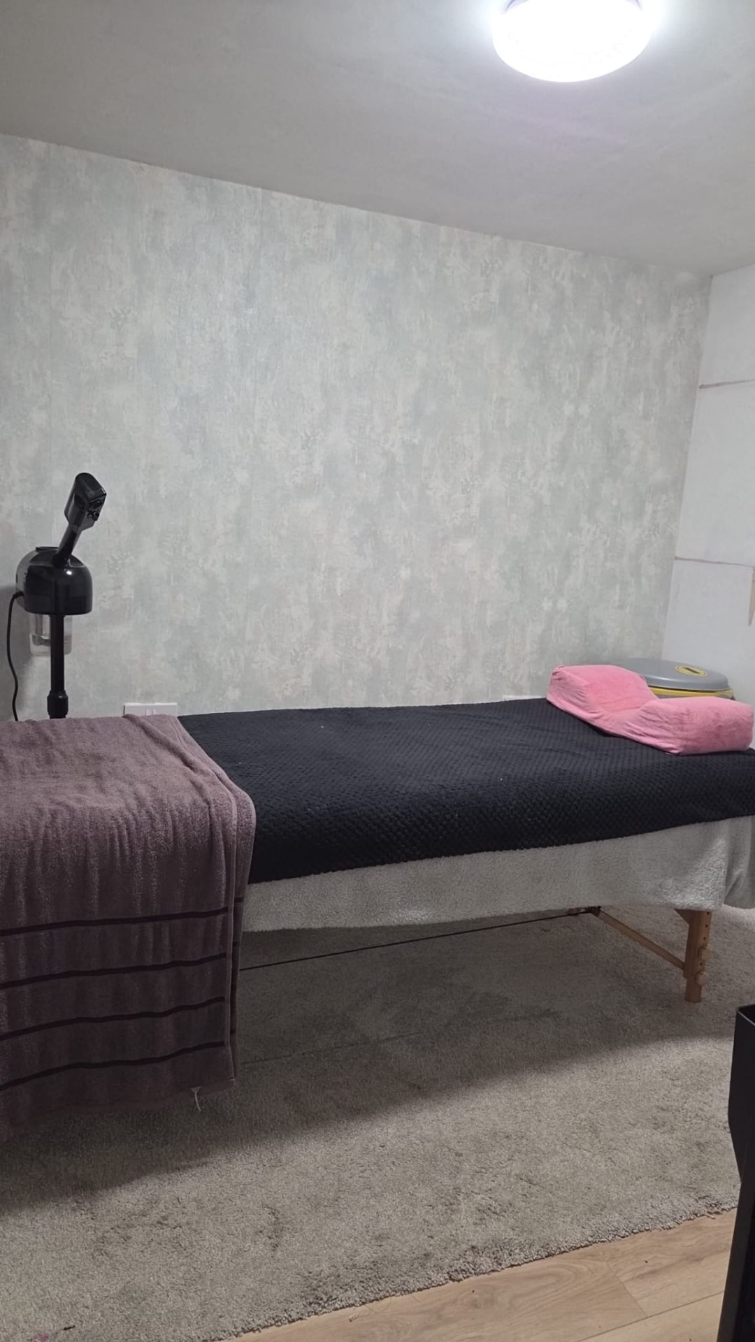 Treatment room with the bed made up and facial steamer ready