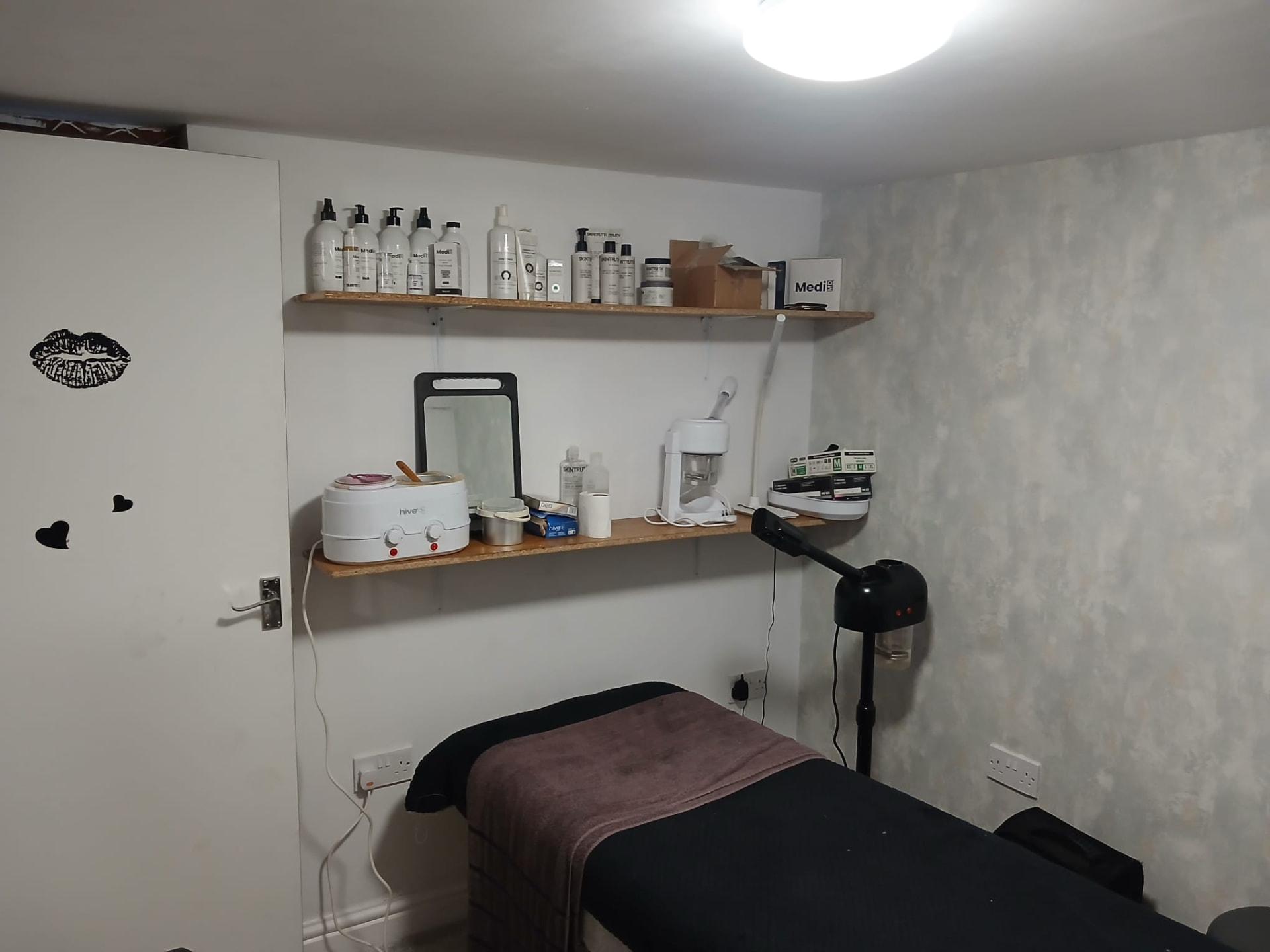 Wax pot, steamer and professional skincare on the studio shelves