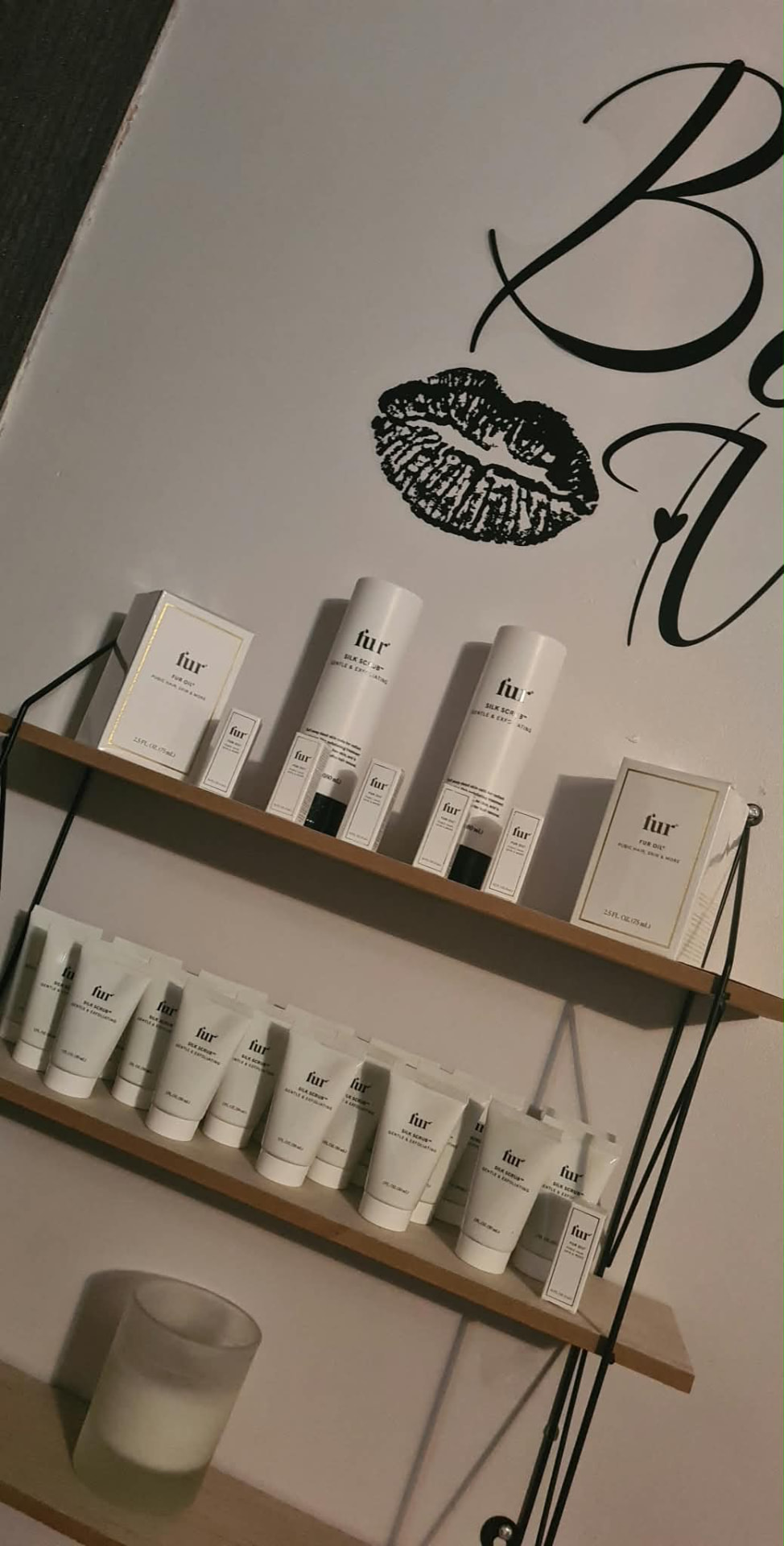 Retail shelf of skincare products with a lip wall decal